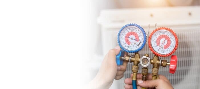 Hands Adjusting Hvac Pressure Gauges With Red And Blue Dials, Ensuring Your Hvac System Is Ready For Spring Maintenance.