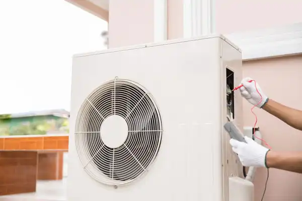 A technician wearing gloves meticulously works on an outdoor air conditioning unit, expertly performing heat pump maintenance in Nashville, TN.